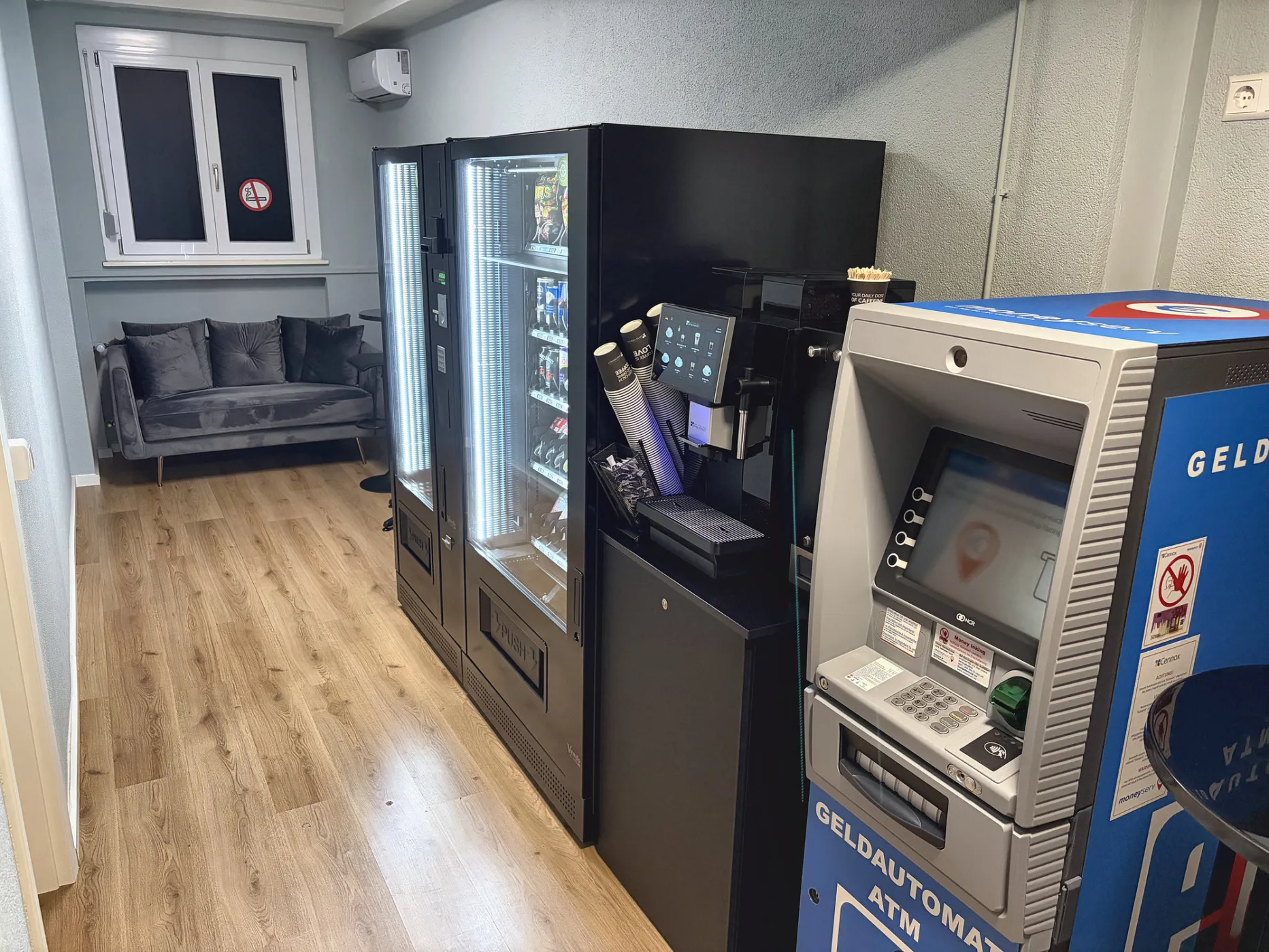 Aufenthaltsraum mit Sofa, Getränkeautomat, Kaffeemaschine und Geldautomat