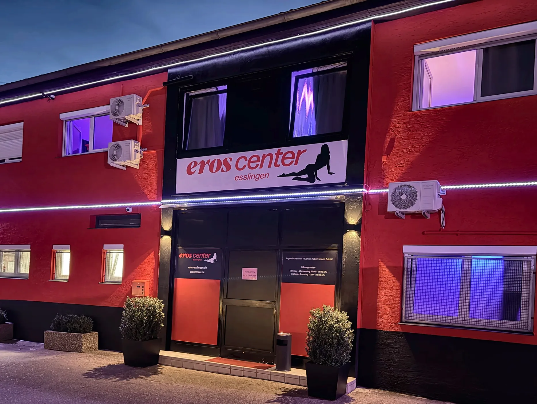 Eingang des Eroscenter Esslingen bei Nacht mit beleuchtetem Schild